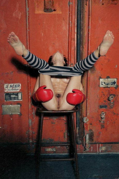 Young brunette Night A doffs striped leggings to pose nude in boxing gloves