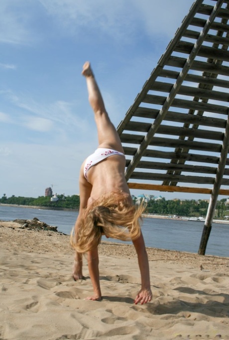 Young blonde Anastasia B does a cartwheel after getting naked on a beach