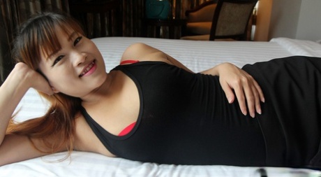 Asian amateur cradles her firm boobs after getting butt naked on a bed