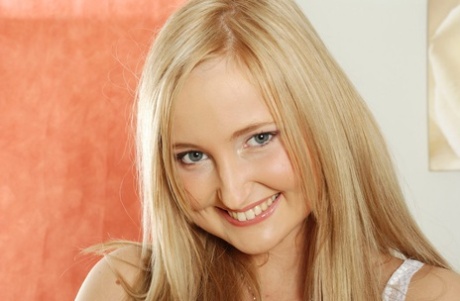 Smiling blonde girl frees her camel toe pussy from short denim shorts