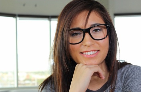 Nerdy brunette Kimberly Costa shows her tiny tits and spreads her butt