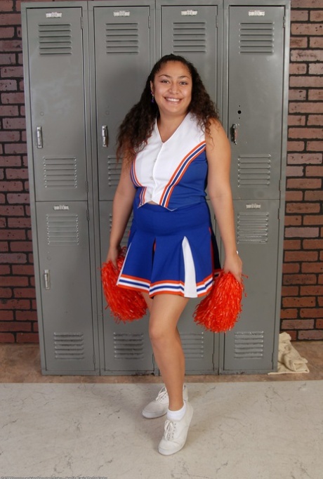 Petite curly haired cheerleader Reena shows her fat ass and hairy pussy
