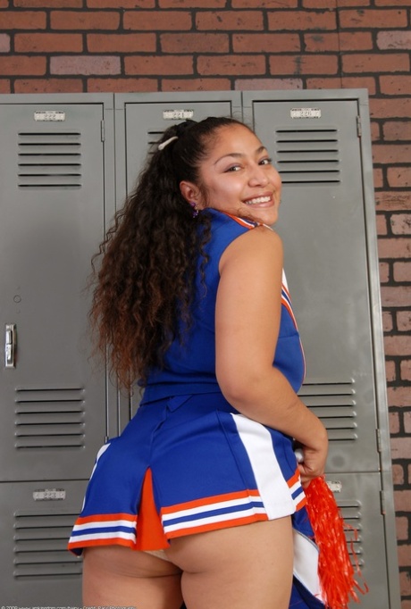 Petite curly haired cheerleader Reena shows her fat ass and hairy pussy