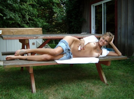 Blonde babe Dawn shows off her hairy pussy & her tanned tits outdoors