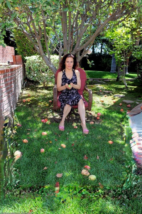 Lustful GILF Marie stripping and posing by a tree in the backyard