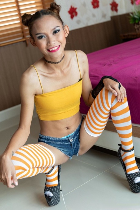 Thai teen Naphasorn strips to her stocking & heels & shows her ass & muff