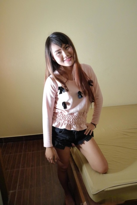 Attractive Asian babe Meu strips & flaunts her big ass and shaved pussy